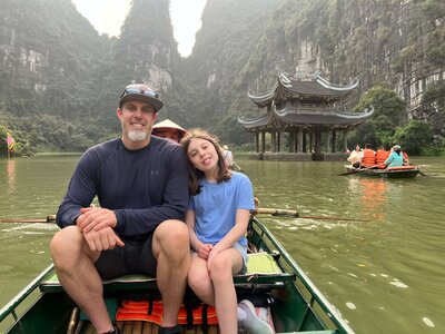 Father and daughter in boat in Tam Coc, Vietnam — snapshot from parenting abroad and travel reflections blog posts