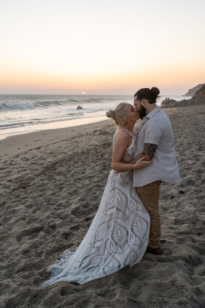 Bride and groom kissing at sunset at their Malibu beach elopement 