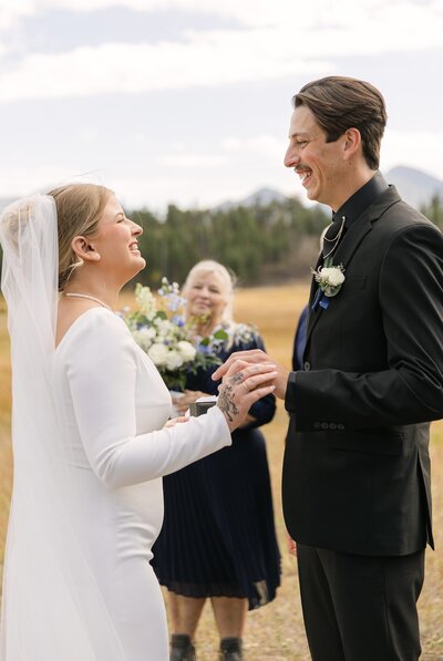 Bride and groom exchanging vows outdoors during their Colorado wedding ceremony in Rocky Mountain National Park