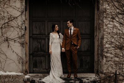 bride and groom standing in front of wedding venue