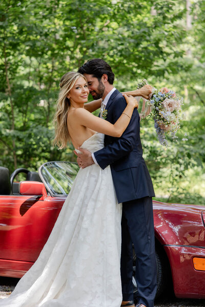 bride and groom embracing next to vintage car atlanta wedding