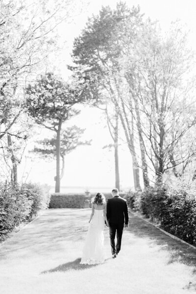Bride and Groom holding hands and walking into the garden at Gileston Manor