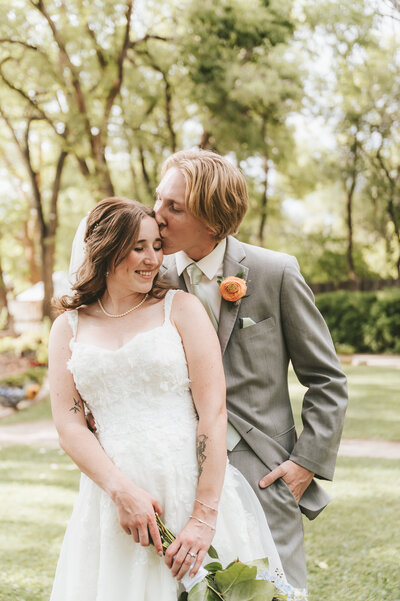 Groom kissing bride on the forehead