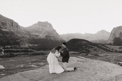 Groom proposing to his bride at a scenic overlook in Glacier National Park
