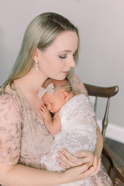 New mother in champagne lace gown snuggles her newborn baby wrapped in lace, by Cambridge, MA newborn photographer Fieldstone Studio