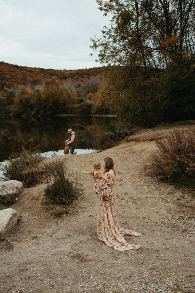 Mother and father holding newborn baby during a cozy newborn session in the studio, natural light highlighting gentle family connection. Mendham, NJ