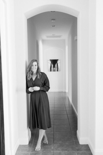 black and white photo of Interior Designer standing in hallway