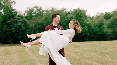 Groom twirls bride in an outdoor field