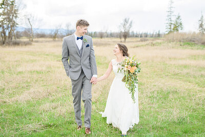 Seattle couple holding hands and bouquet while walking