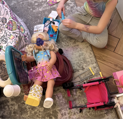 Child playing with a doll wearing an oxygen mask