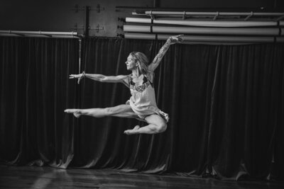 A dancer in a studio jumping in the air 