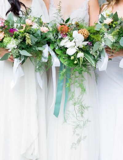 close-up of bride and braidsmaids bouquets all wearing white