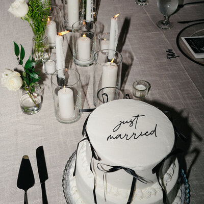 a just married wedding cake with candle light at the wedding reception