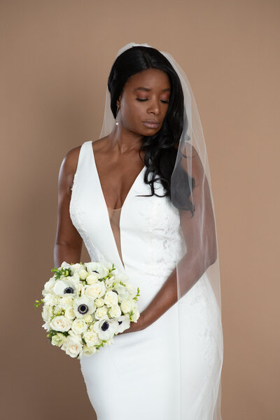 bride wearing a cathedral length veil and holding a white and blush bouquet