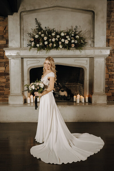 Bride standing in front of the Lake House fireplace in Calgary
