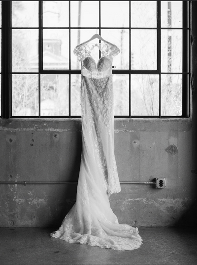 black and white photo of bridal gown hanging up