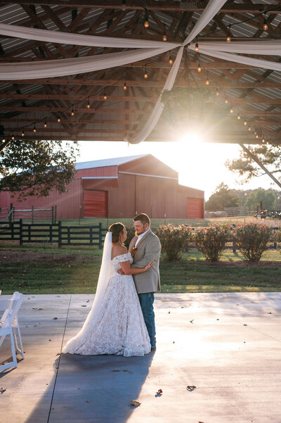 bride and groom having first dance at sunset at Five Dollar Farm wedding Venue in Rock Spring GA