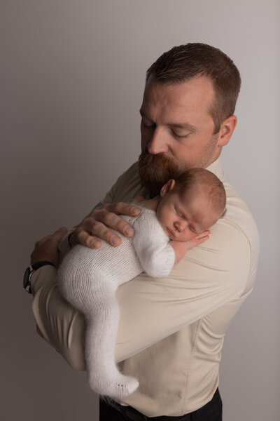 dad holding baby on his arm