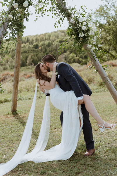 bride and groom unique wedding dress with cape white florals le peaches and cream