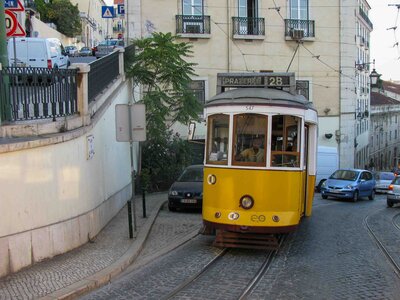 A vintage yellow tram winding up a steep cobblestone street in Lisbon’s historic district ©Stephanie Dosch | theViatrix Portugal Luxury Private Travel