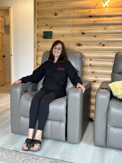 Bea Weir sitting in a wellness space at EnerBea, welcoming clients for wholistic healing sessions.