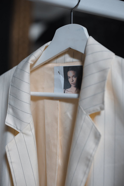Artistic interplay of fashion and imagery, with a monochrome photo peering through a white structured jacket