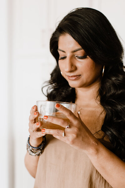 Nutrition coach Radhika holding a cup of herbal tea
