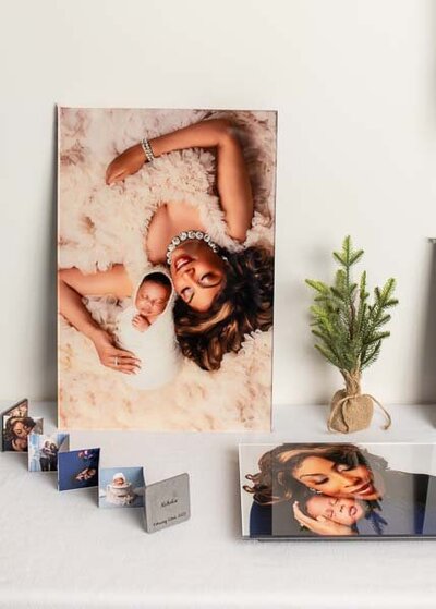 Newborn Photography - Fine art newborn wall portrait and printed photo products displayed on a white surface, featuring a mother and baby from a studio photography session by Misty Dawn Photography in Birmingham, AL.
