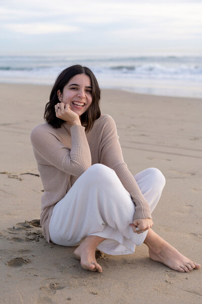 girl sitting on beach during photoshoot