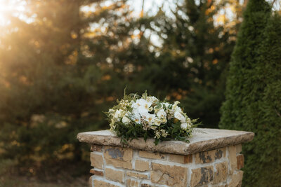 The bride's wedding bouquet on a stone pillar.