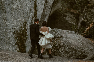 bride and groom hiking along the trail to taft point