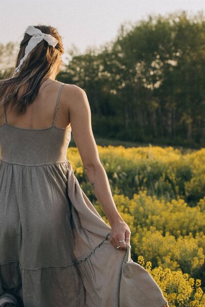 Minnesota wedding photographer walks through field at sunset