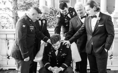 Groomsmen patting groom on the shoulder in a Palm Coast wedding black and white