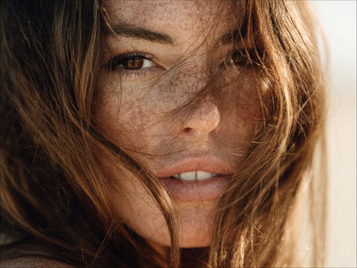 Natural close-up portrait of a woman in soft sunlight, reflecting the effortless beauty and confident energy behind Kathalyst Design Studio’s brand aesthetic.