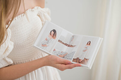 Jessica Jeremiah Photography holding album of maternity portraits