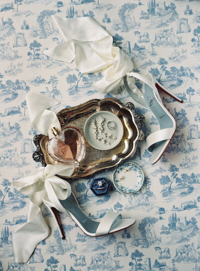 Flat lay of wedding invitation suite with wedding rings and orange flowers