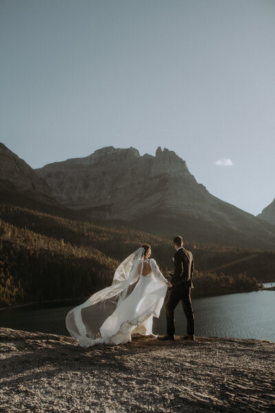 husband kissing wife's hand during elopement photos in montana