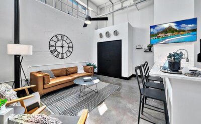 Vintage industrial living room in this one-bedroom, one-bathroom luxury rental condo in the historic Behrens building in downtown Waco within walking distance to the Silos, Baylor, and local museums.