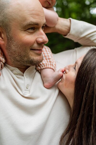 A candid close-up of parents playing with baby daughter's toes during an outdoor family photography session in Cleveland.
