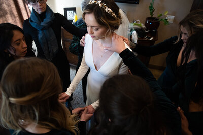 groupf of women praying over brdie 
