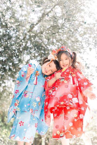 Two girls in Hello Kitty kimono smiling outdoors — ハローキティ着物の女の子 二人 仲良し 七五三 ロサンゼルス