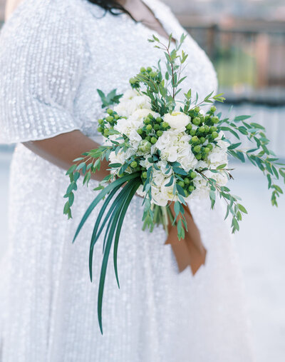 A bride holding her white flowers to her side by Colorado wedding photographer JKG Photography