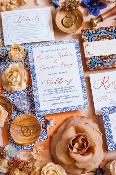 Flatlay photo of a blue and orange wedding invitation suite