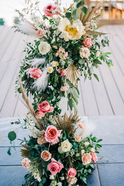 green floral garland with pink and yellow flowers
