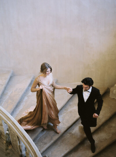 Bride and groom running down stairs on wedding day in Los Angeles