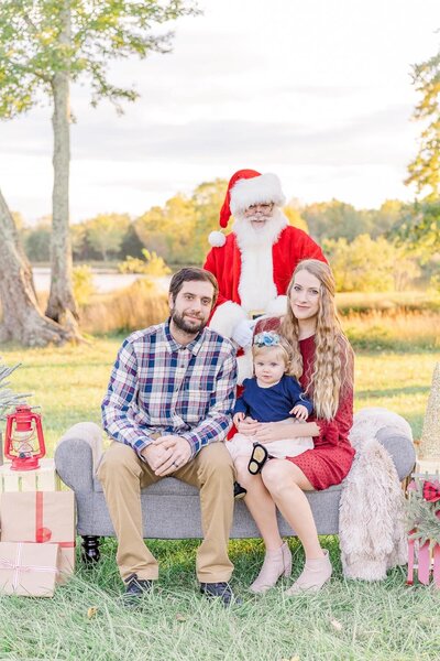family of 3 with Santa during their Christmas mini session in Haymarket, Virginia
