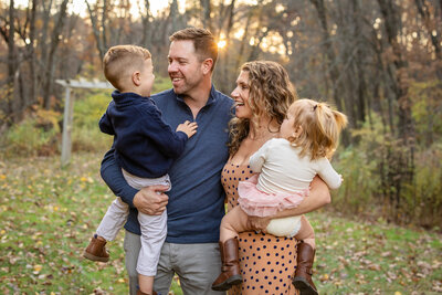 Family of four snuggling during fall family photos in Sudbury, MA