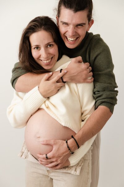 deux futurs parents heureux pendant leur shooting grossesse avec studio sensigraphie photographe grossesse la tour du pin en isère