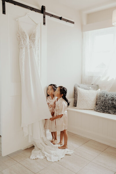 Flower girls looking at wedding dress