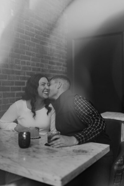 a couple embracing with the city behind them